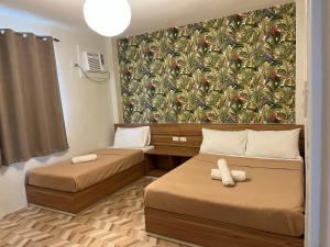 ein kleines Zimmer mit 2 Betten und einer Tapete in der Unterkunft Red Knight Gardens in Davao City