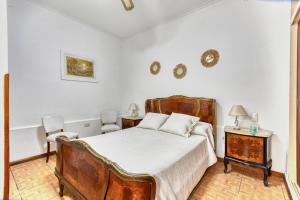 a bedroom with a large bed and two chairs at La casa de tigre Centro in Tigre