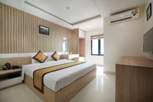 sypialnia z dużym łóżkiem i telewizorem w obiekcie Sunflower Hotel w mieście Cát Bà