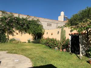 a house with a yard with flowers and a building at Casa Cafayate in Cafayate