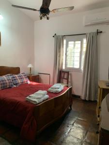 a bedroom with a bed with red sheets and a window at Casa Cafayate in Cafayate