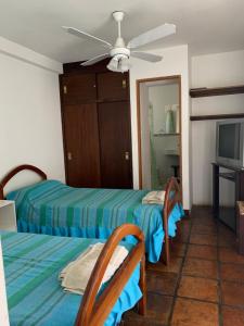 a bedroom with two beds and a ceiling fan at Casa Cafayate in Cafayate