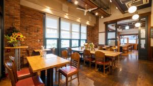 a restaurant with tables and chairs and a brick wall at JR-East Hotel Mets Kawasaki in Kawasaki