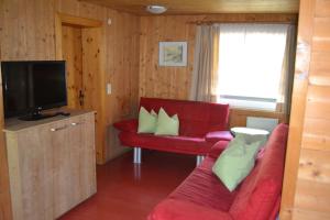 sala de estar con sofá rojo y TV en Apartment Renate, en Fügen