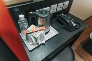 a counter with a coffee maker and a bottle of water at Hotel 81 Heritage in Singapore