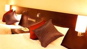 a hotel room with a bed with a pillow on it at JR-East Hotel Mets Yokohama Tsurumi in Yokohama