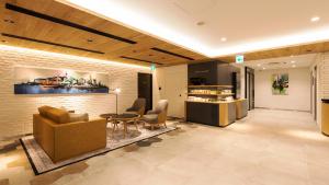 a lobby with a couch and a table and chairs at JR-East Hotel Mets Yokohama in Yokohama