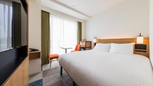 Postel nebo postele na pokoji v ubytování JR East Hotel Mets Premier Yokohama Sakuragicho