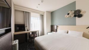 Postel nebo postele na pokoji v ubytování JR-East Hotel Mets Mizonokuchi