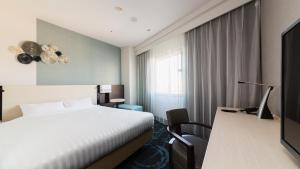 Postel nebo postele na pokoji v ubytování JR-East Hotel Mets Mizonokuchi