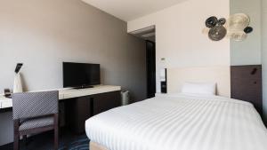 Postel nebo postele na pokoji v ubytování JR-East Hotel Mets Mizonokuchi
