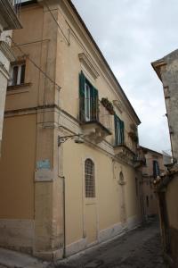 ein Gebäude mit grünen Türen und Balkonen auf einer Straße in der Unterkunft La Chiave di Volta in Ragusa