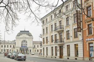 un bâtiment dans une rue avec des voitures garées devant elle dans l'établissement Hotel Gal, à Tarnów