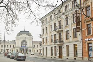 a building on a street with cars parked in front of it at Hotel Gal in Tarnów