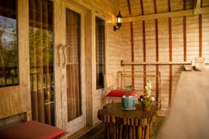 eine abgeschirmte Veranda mit einem Tisch und einem Fenster in der Unterkunft Wisnu Lumbung Uluwatu in Uluwatu