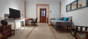 ein Wohnzimmer mit einem Bett und einem TV in der Unterkunft Increíble casa y parcela en Huasco Bajo. in Huasco Bajo