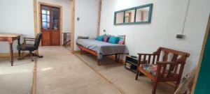 Zimmer mit einem Bett, 2 Stühlen und einem Schreibtisch in der Unterkunft Increíble casa y parcela en Huasco Bajo. in Huasco Bajo