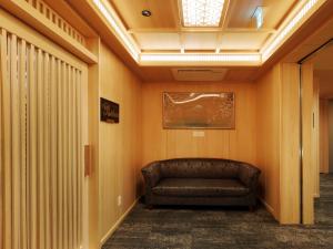 a leather couch in a hallway with a ceiling at Hotel Shikinoyakata Hakone Ashinoko in Hakone