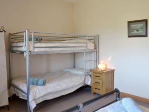 two bunk beds in a room with a night stand at Laird House in Lochmaben