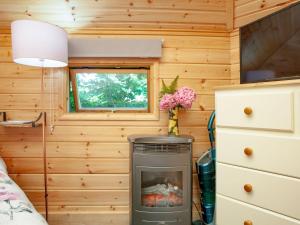 a tiny house with a fireplace in a bedroom at Coot Roundhouse - Uk33890 in Cullompton