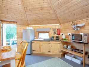 cocina con paredes de madera y techo de madera en Coot Roundhouse - Uk33890, en Cullompton