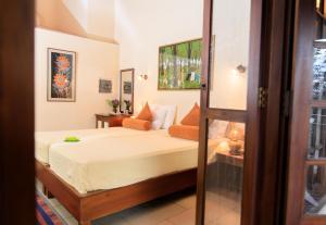 1 dormitorio con 1 cama con sábanas blancas y almohadas de color naranja en Spring of Life, en Colombo