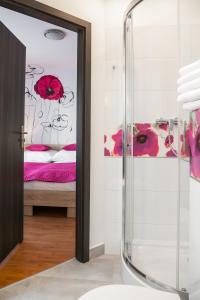 a bathroom with a glass shower and a bed at Villa Margo in Białystok
