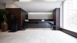 an office lobby with a desk and a large window at JR-East Hotel Mets Komagome in Tokyo