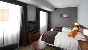 a hotel room with a bed and a television at JR-East Hotel Mets Komagome in Tokyo +30 photos