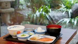 un vassoio di cibo con ciotole di zuppa e uova di HOTEL UNIZO Kyoto Karasuma Oike a Kyoto