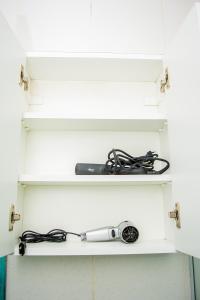 a whisk and cables are sitting on a shelf at Apartamento Central - Shopping-Carrefour-Universidade in Pelotas