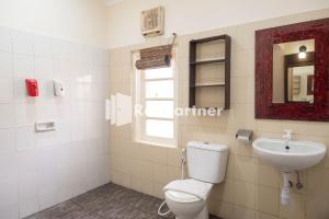 ジョグジャカルタにあるMonginsidi Guest House Syariah Malioboro Yogyakarta Mitra RedDoorzのトイレと洗面台付きのバスルーム +46枚の写真