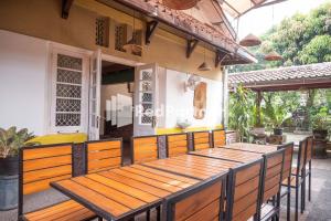 einen Holztisch und Stühle auf einer Terrasse in der Unterkunft Monginsidi Guest House Syariah Malioboro Yogyakarta Mitra RedDoorz in Yogyakarta