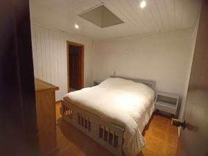 a small bedroom with a white bed in a room at Cabaña Anita in El Quisco