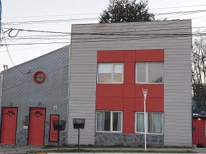 a red and gray building with red doors at Jauke Departamentos in Ushuaia