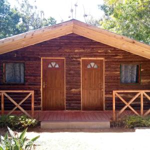 a log cabin with two doors and a porch at Three Palms Fianar in Fianarantsoa