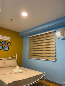 - une chambre avec un lit et une fenêtre avec des stores dans l'établissement YeYengs Transient, à Manille