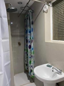 a bathroom with a sink and a shower curtain at YeYengs Transient in Manila