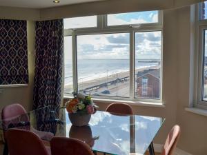 a dining room with a table and a view of the beach at Crows Nest in Bridlington