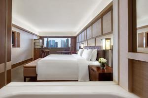 a hotel room with a large bed and a window at Pan Pacific Singapore in Singapore