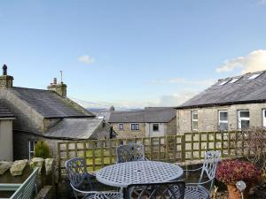 a table and chairs on a patio with a fence at View Cottage in Settle