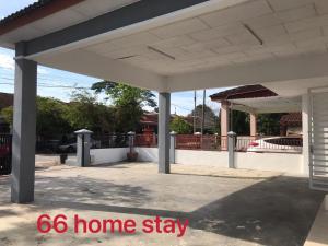 a white homestay with a porch and a driveway at 66 Semi-D Homestay in Teluk Intan