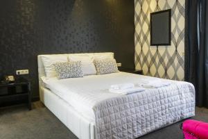 
a white bed with a white comforter and pillows at Hotel Zwanenburg Amsterdam Airport in Zwanenburg
