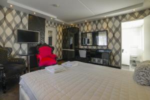 
a hotel room with a bed, desk and television at Hotel Zwanenburg Amsterdam Airport in Zwanenburg
