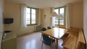 Un comedor con mesa y sillas de madera. en Apartamentos Montserrat Abat Marcet, en Montserrat