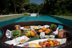 ein Tablett mit Essen auf einem Tisch neben einem Pool in der Unterkunft Jusandi in Ishigaki-jima