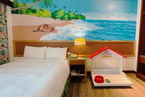 una camera da letto con un letto e un quadro sul muro di Howard Kenting Wonder House a Kenting