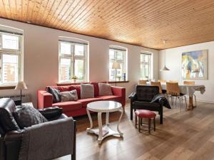 Marstalにある5 person holiday home in Marstalのリビングルーム(赤いソファ、テーブル付)