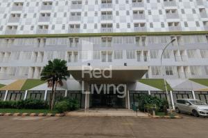a large white building with a red living sign on it at RedLiving Apartemen Gunung Putri Square - TOP Room in Parungtandjung