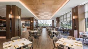 a restaurant with wooden ceilings and tables and chairs at Grand Banyan Hotel in Tainan
